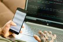 Homem com celular e notebook